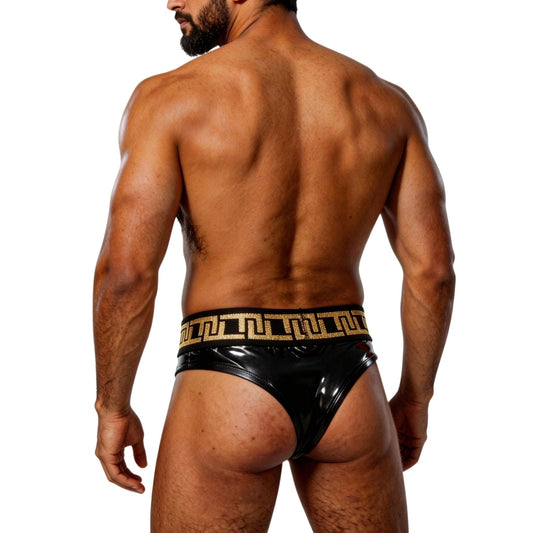 Man wearing a black thong underwear with gold detailing on a white background