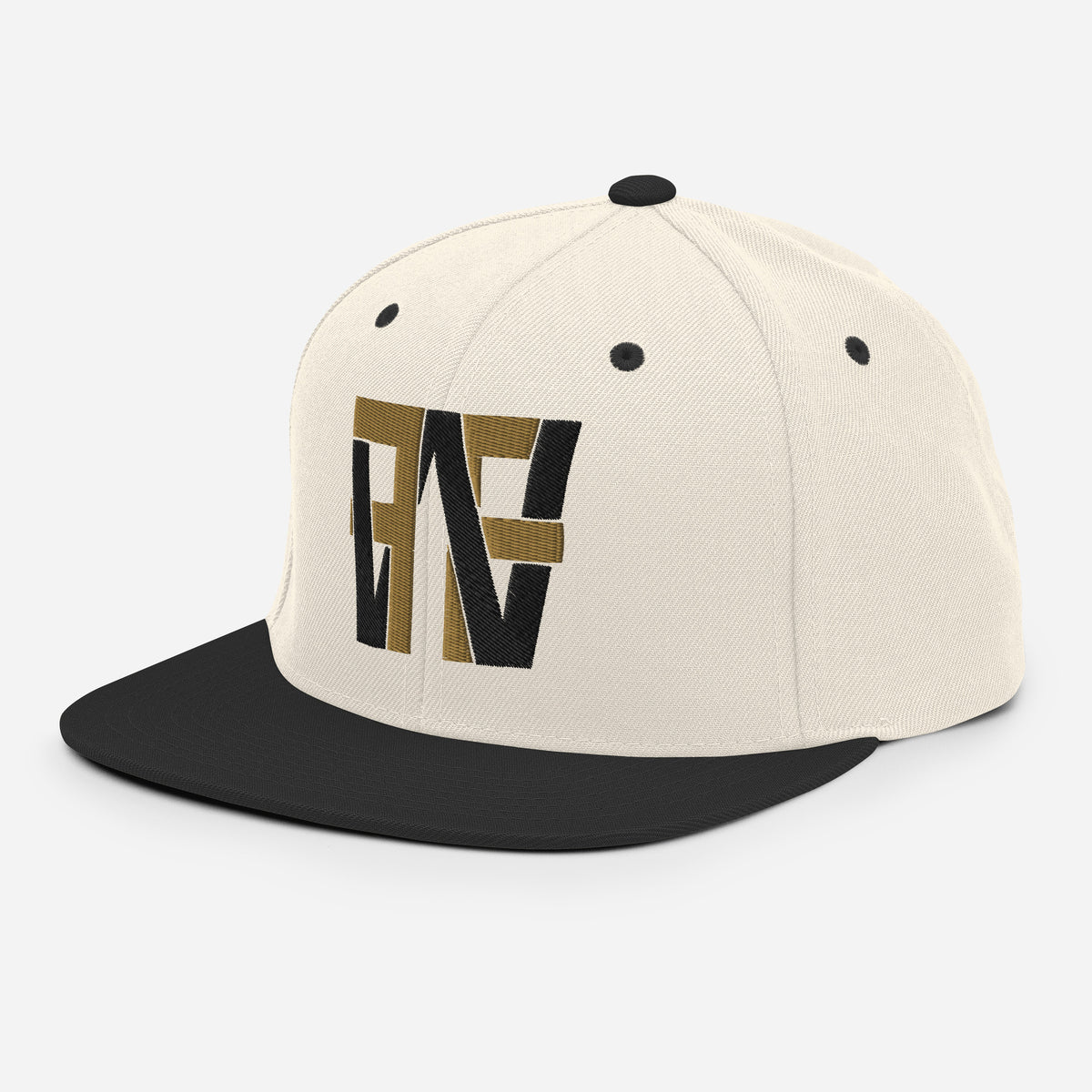 Angled front view of cream FULTON snapback with gold-and-black monogram and brim pointing left